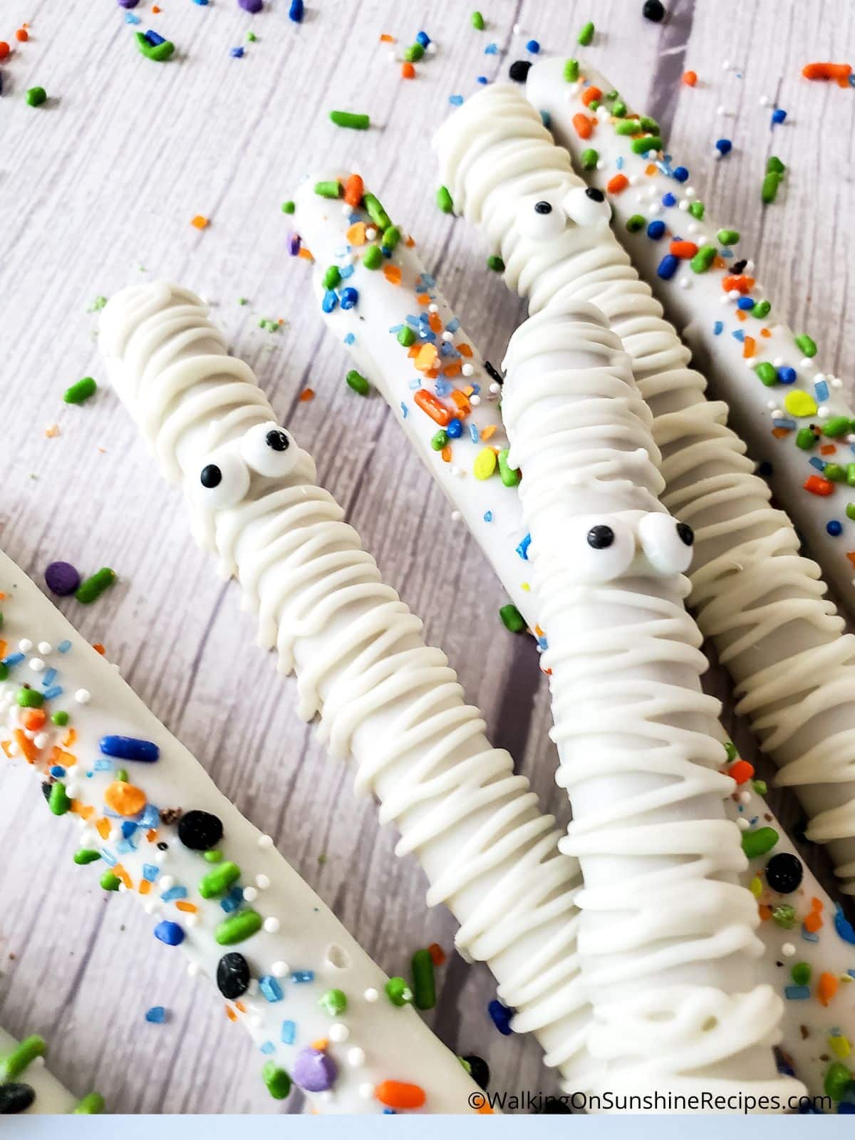 sprinkles and candy eyes on chocolate covered pretzels.