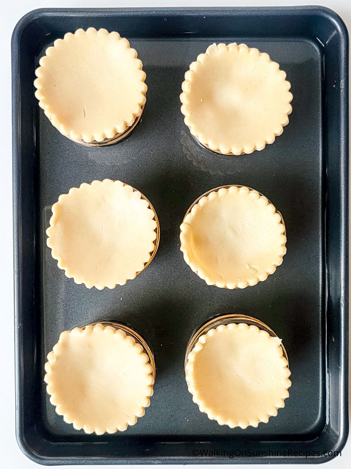 mini apple pies in baking tray.
