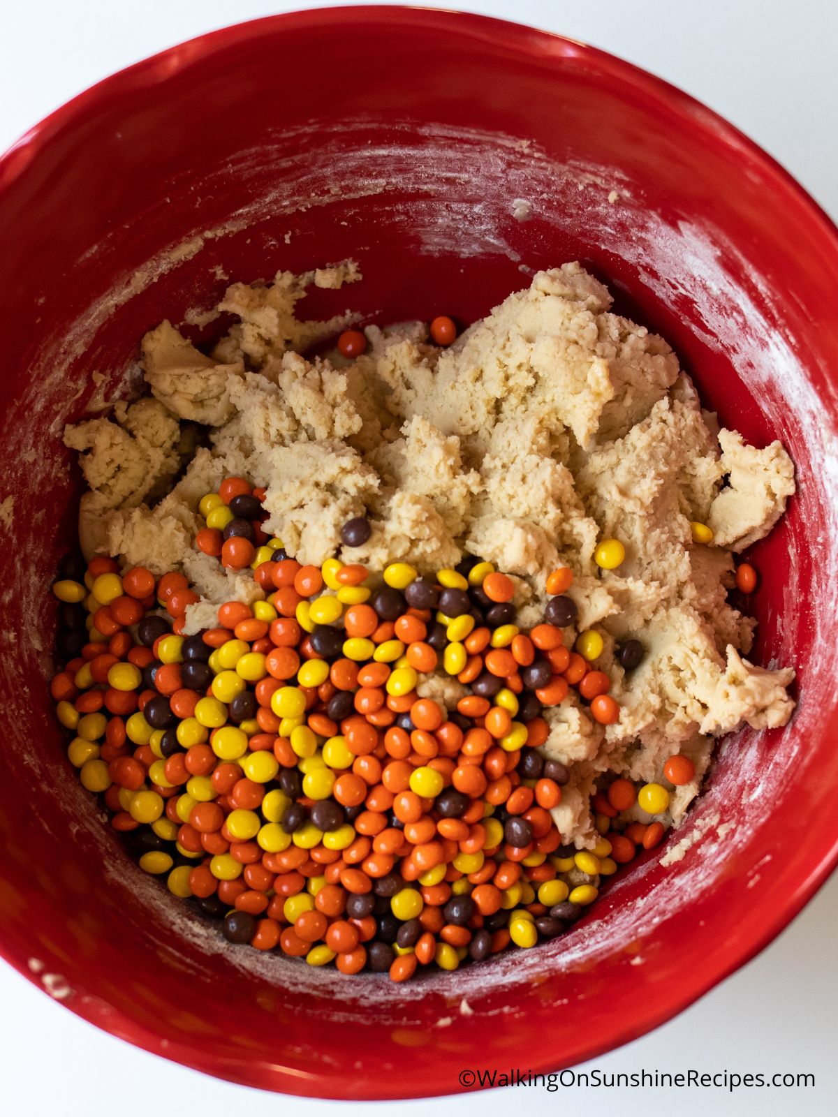 Reese's peanut butter pieces in cookie dough in bowl.
