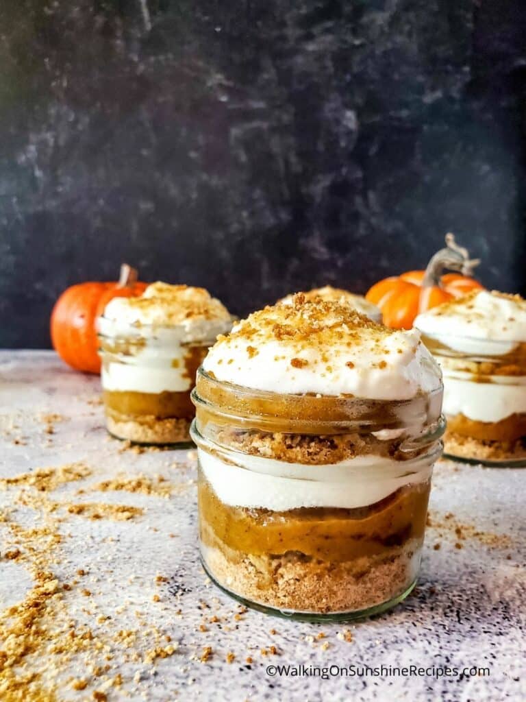 Mason jar pumpkin cheesecake topped with whipped cream.
