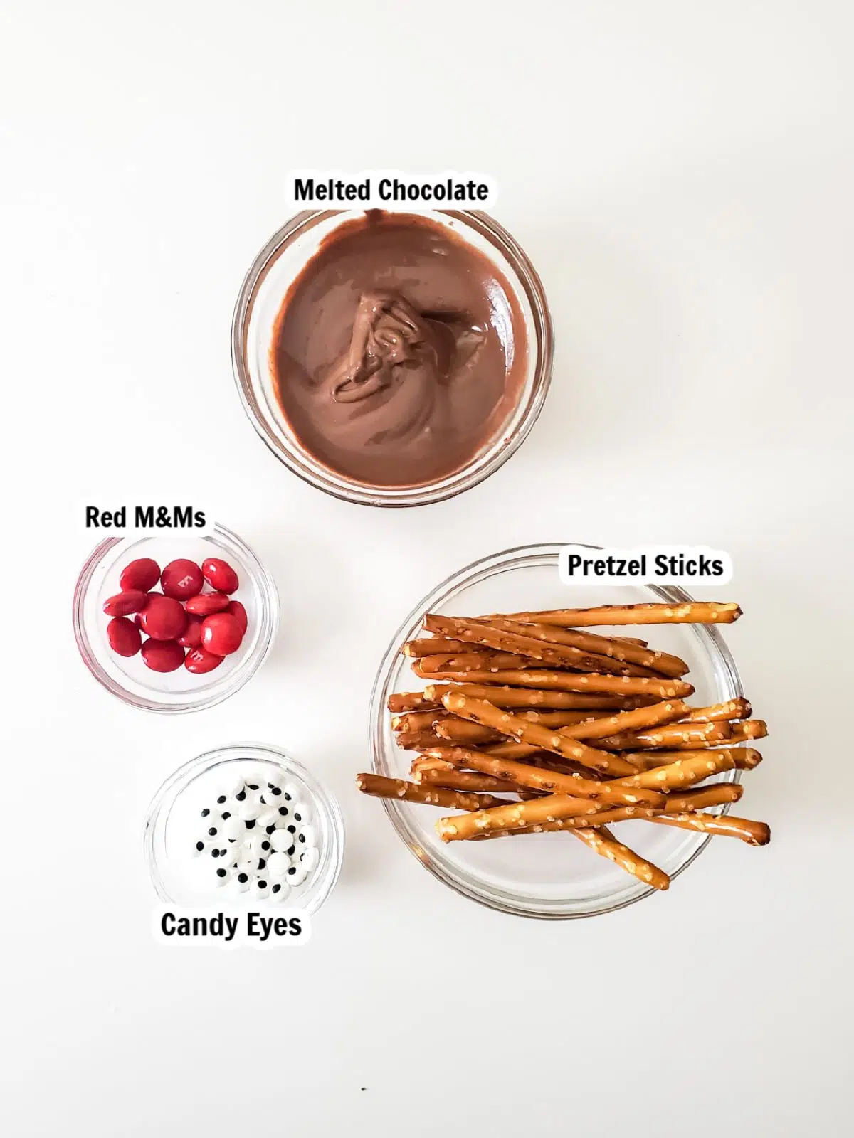 Ingredients - pretzel sticks, candy eyes, melted chocolate.
