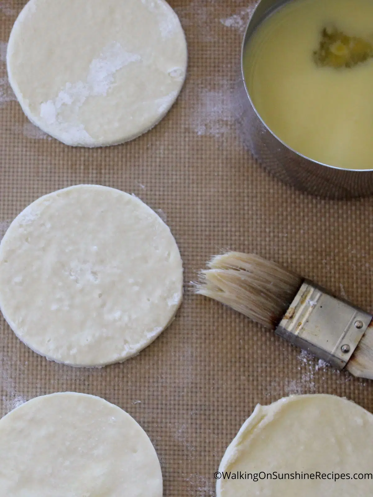 Brush puff pastry circles with butter.