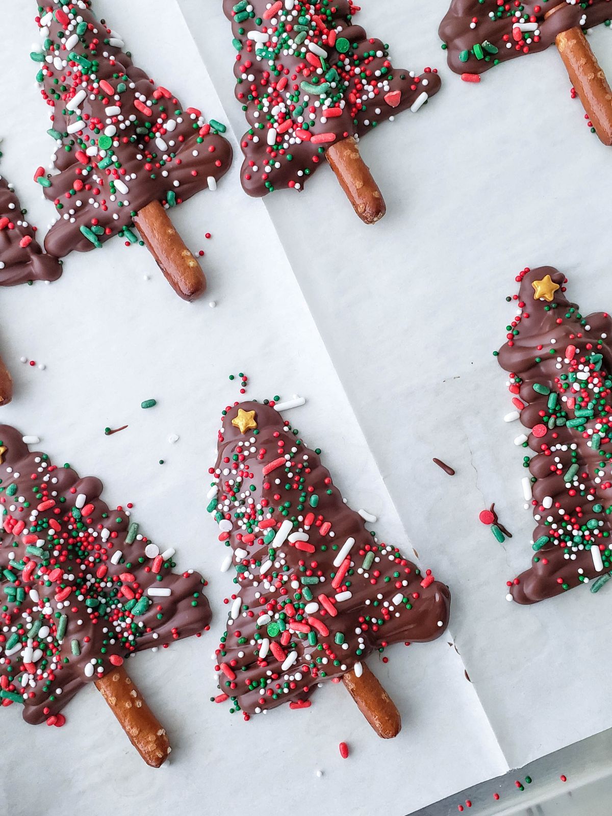 chocolate Christmas pretzel trees on parchment paper.