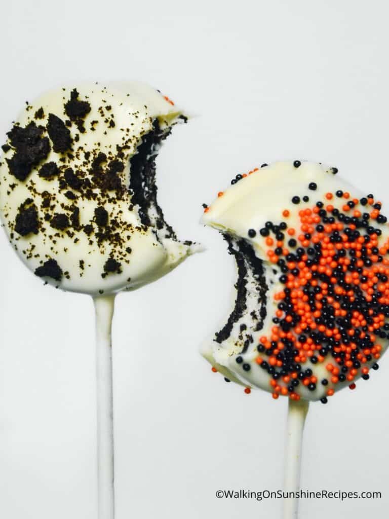 2 chocolate covered Oreos on lollipop sticks.