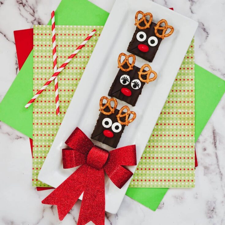 brownies that look like rudolph on white plate with red bow.