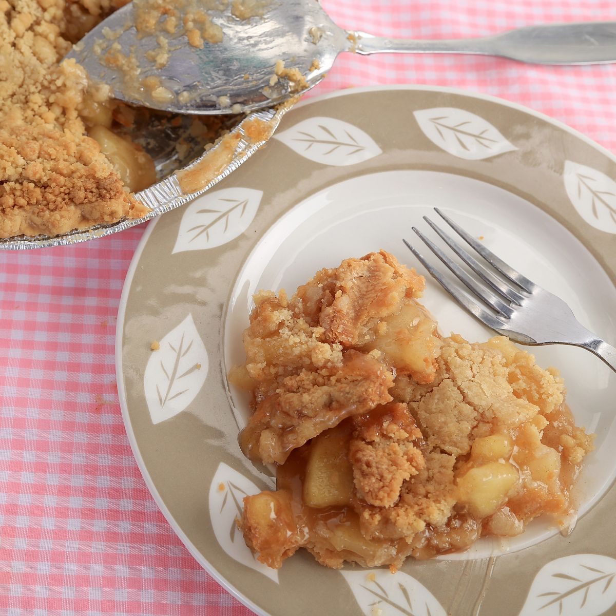 apple crumb pie sliced and served on plate with fork.
