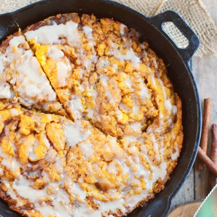Pumpkin Crumb Coffee Cake with powdered sugar glaze baked in a cast iron skillet.