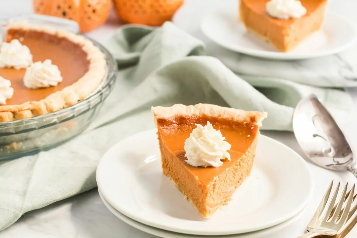 slice of pumpkin pie served on a white plate.