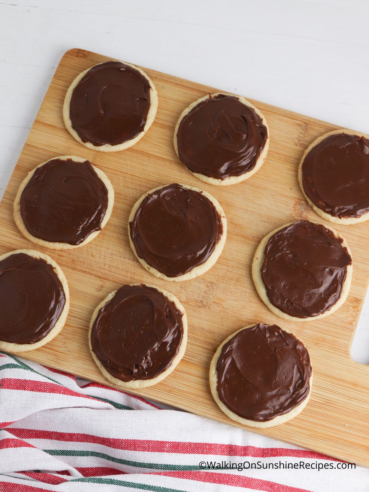 spread chocolate frosting on baked sugar cookies.