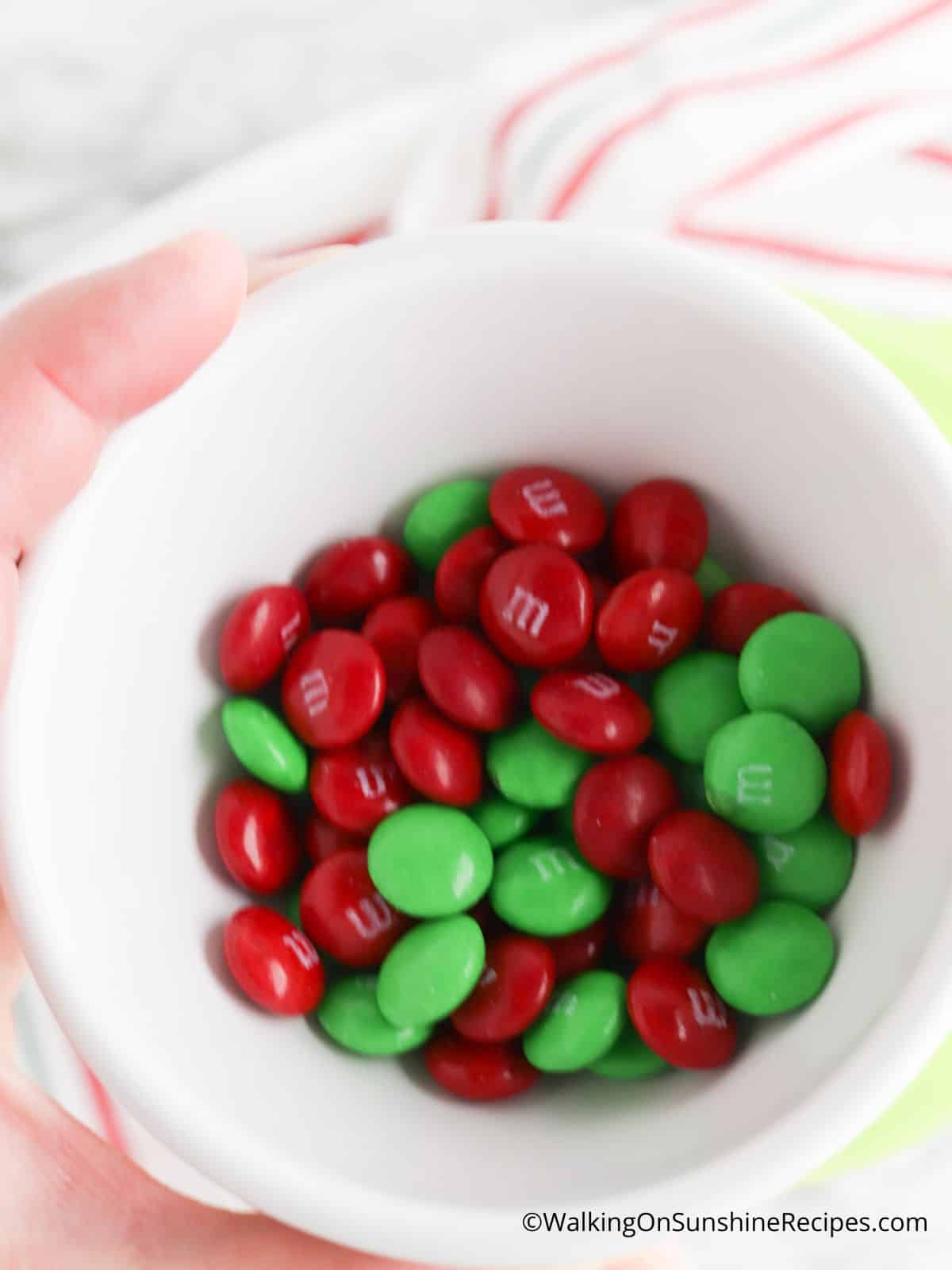 red and green M&Ms in bowl for mason jar cookies.