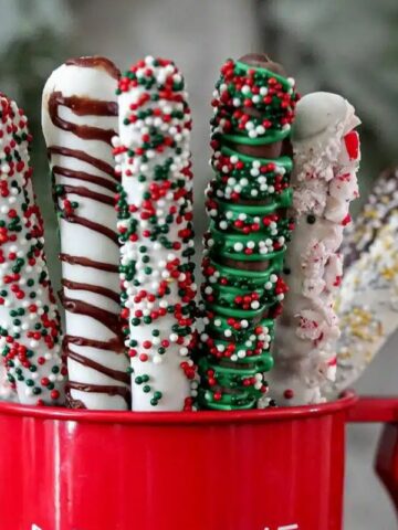 Chocolate-covered pretzels in a red mug.