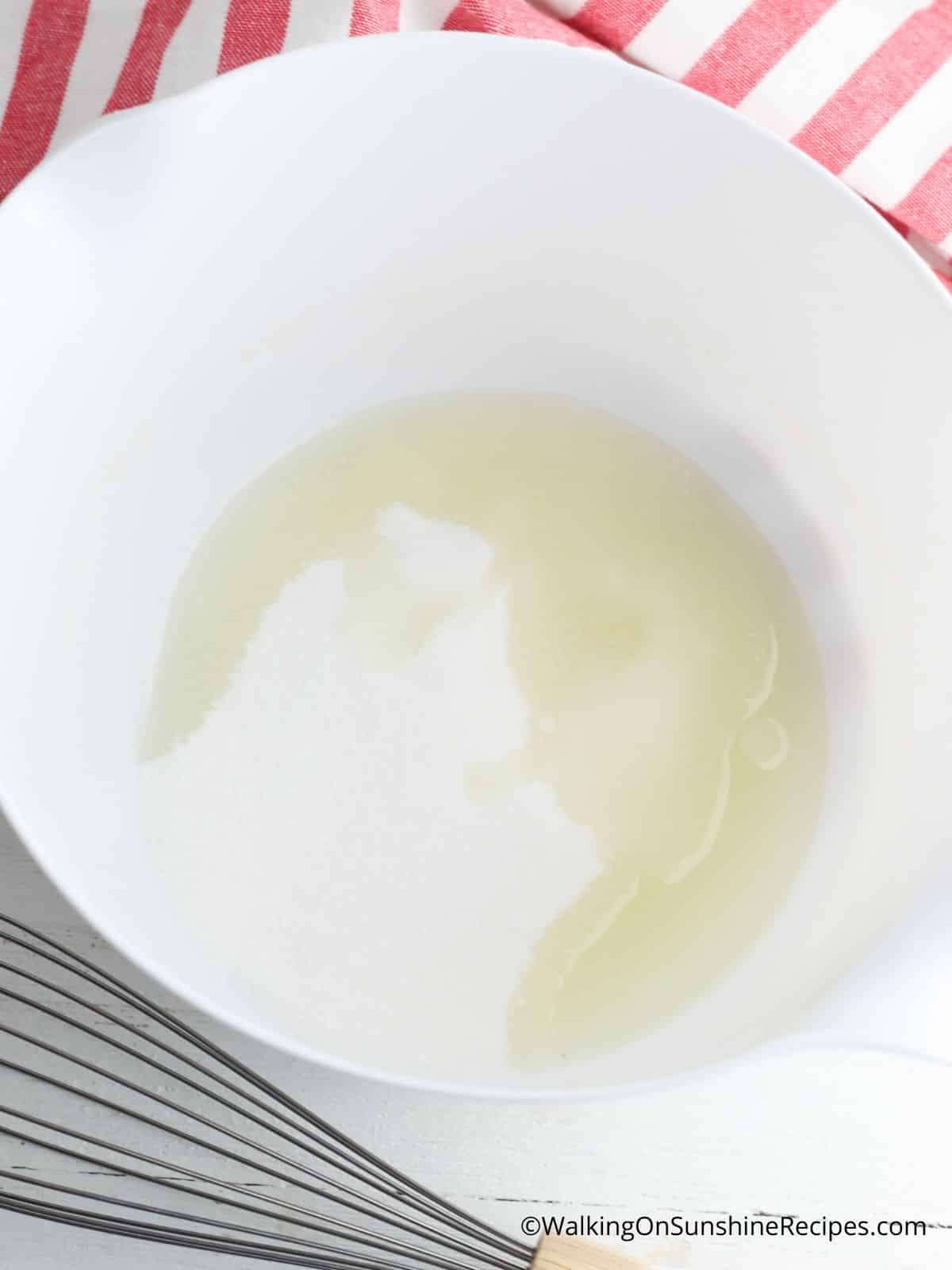 Cream sugar and oil together in bowl.