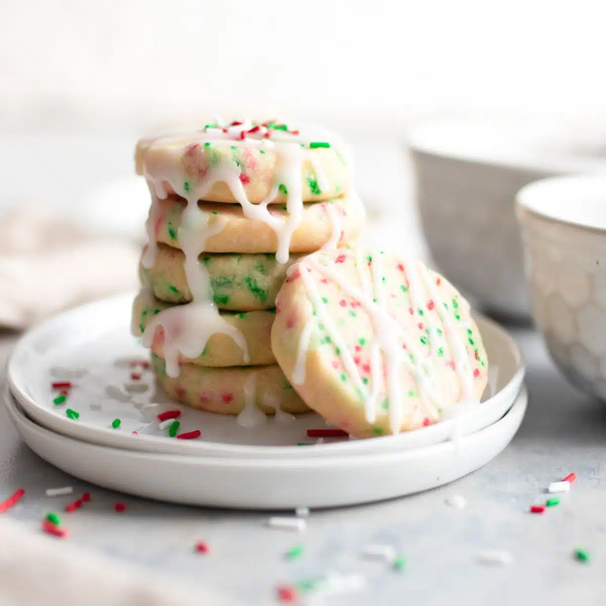 Slice and bake Christmas cookies on white dish with sprinkles.