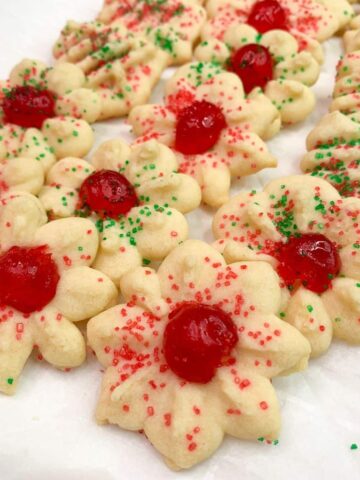 Old fashion spritz cookies with cherries and sprinkles.