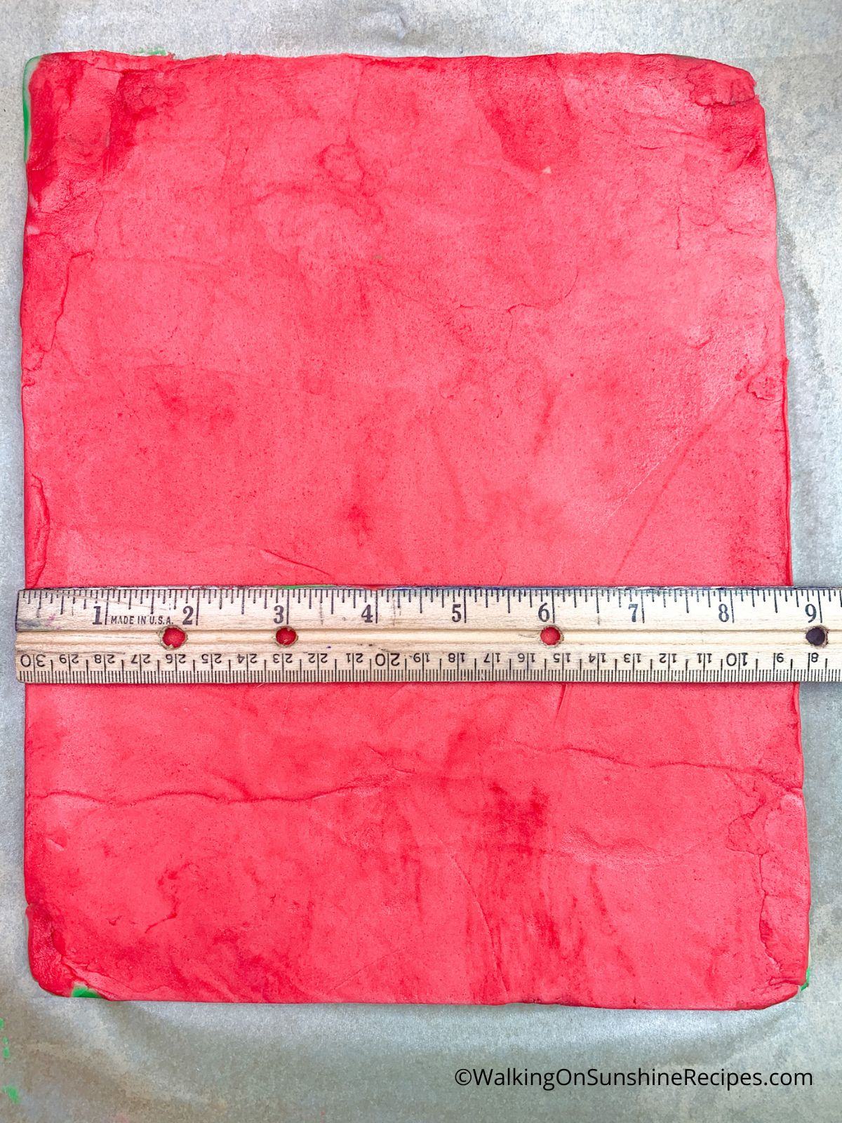 Measuring red rolled out dough.
