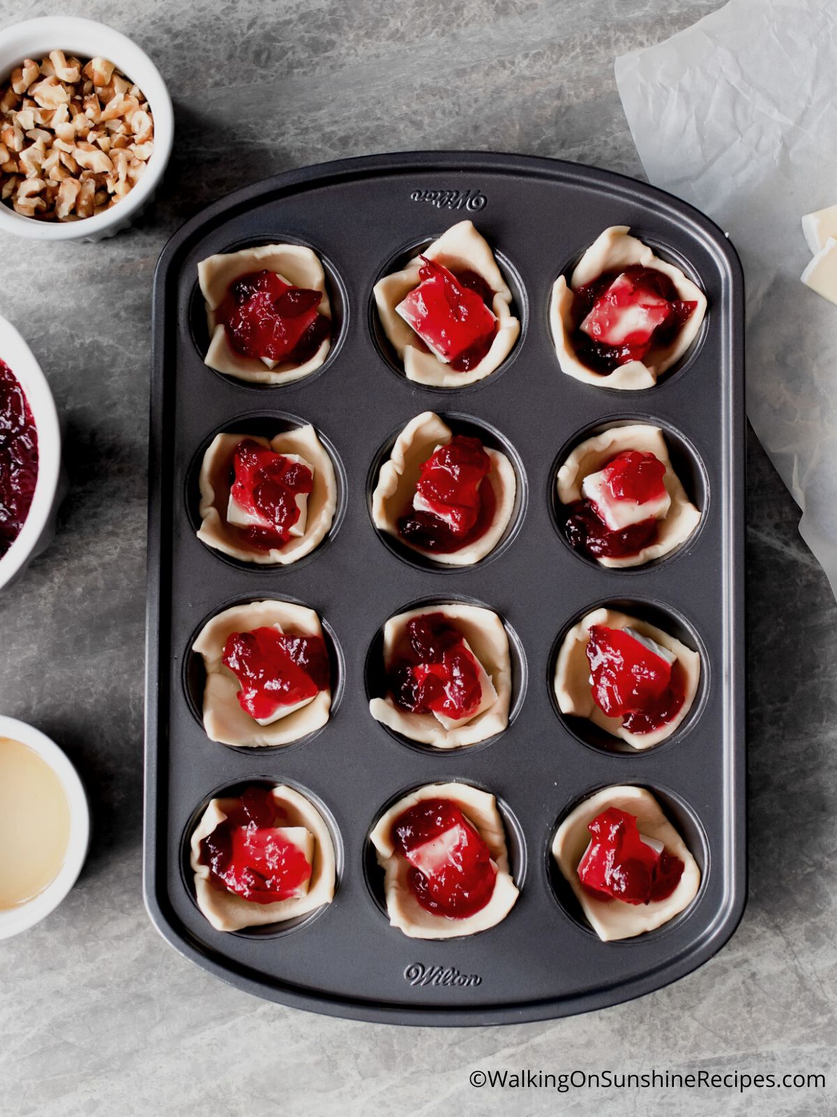Add cranberry sauce on top of brie cheese.
