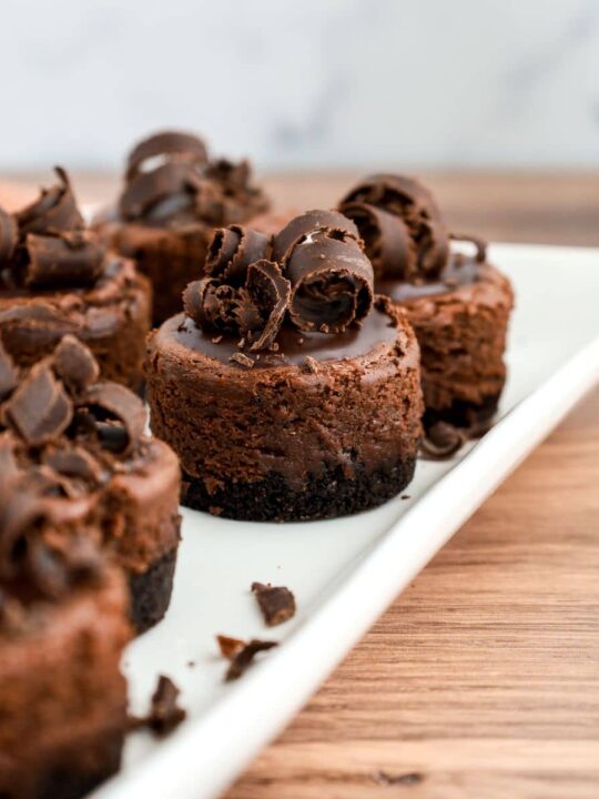 https://walkingonsunshinerecipes.com/wp-content/uploads/2023/01/FEATURED-NEW-SIZE-chocolate-cheesecake.--540x720.jpg