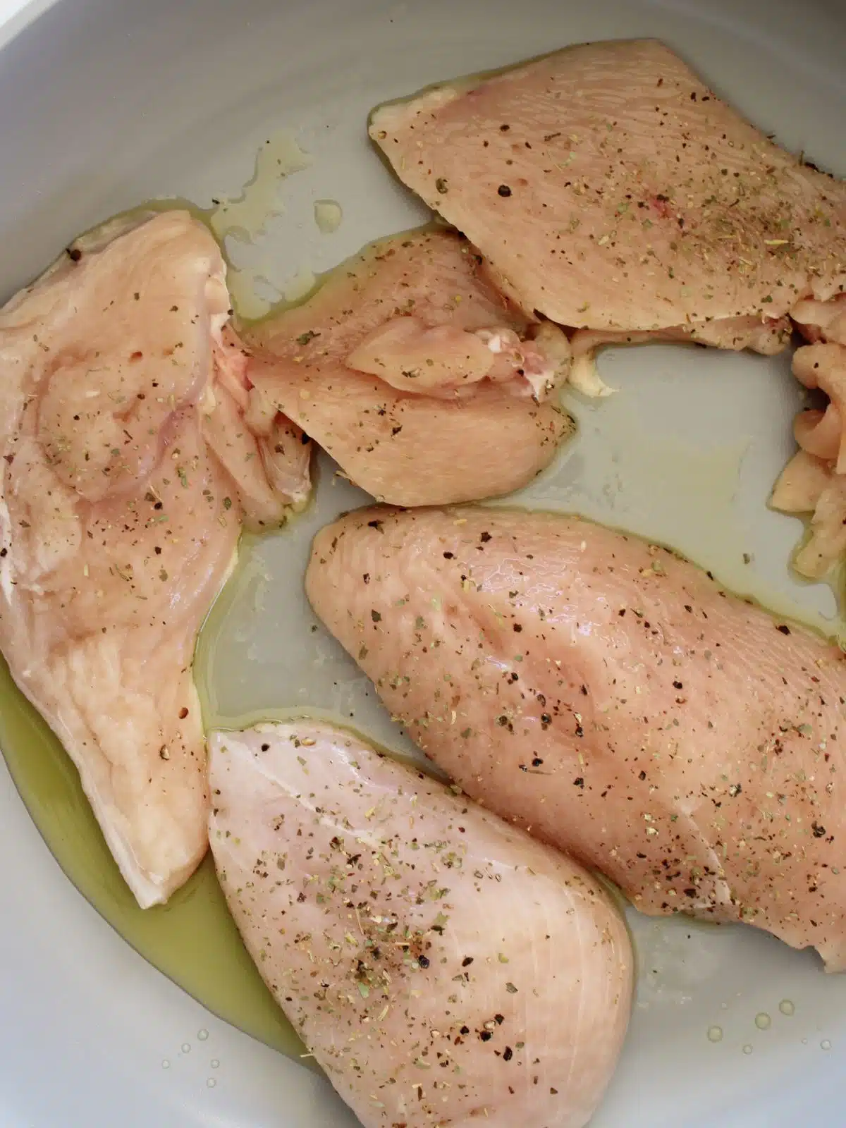 Seasoned chicken cutlets in a pan