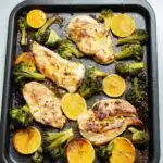 chicken, broccoli and orange slices baked on a sheet pan