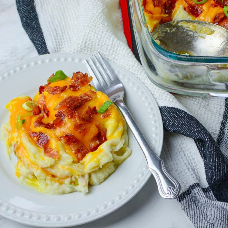 mashed potatoes with cheese and bacon on white plate.