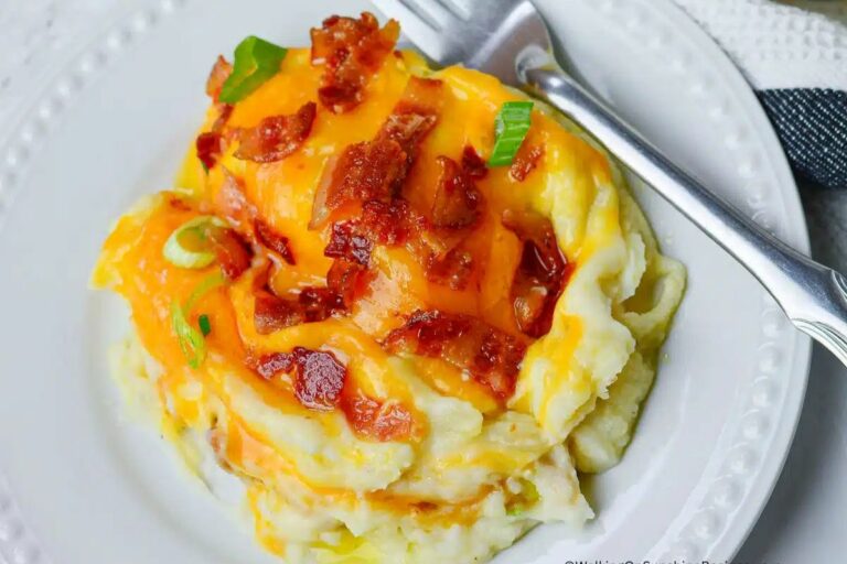 A plate of loaded mashed potatoes with bacon and cheese.