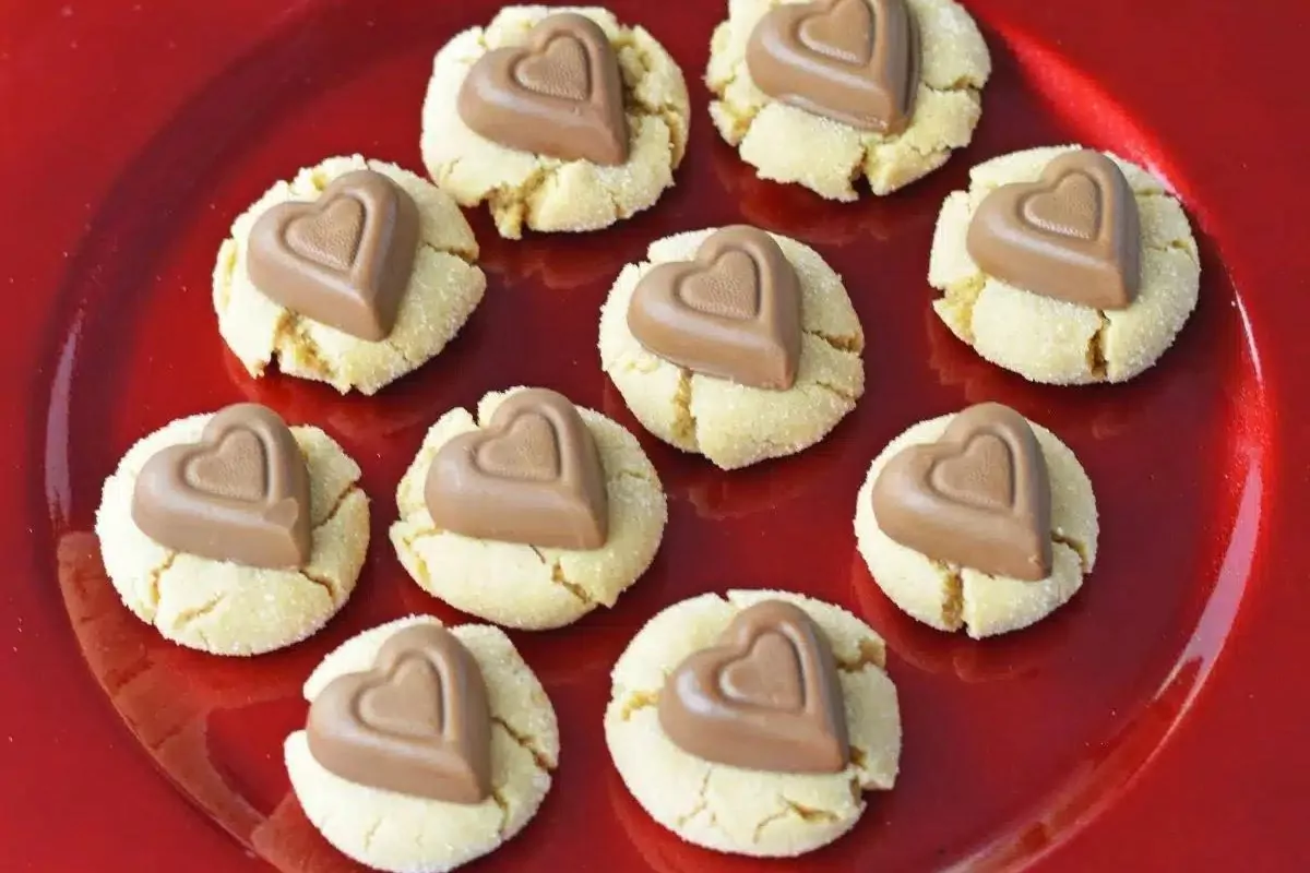 Cookies with heart-shaped chocolates on a red plate.