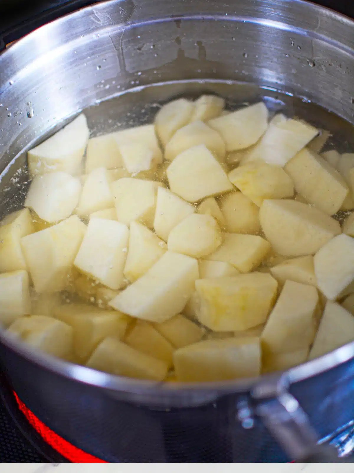 peeled potatoes in pot with water.