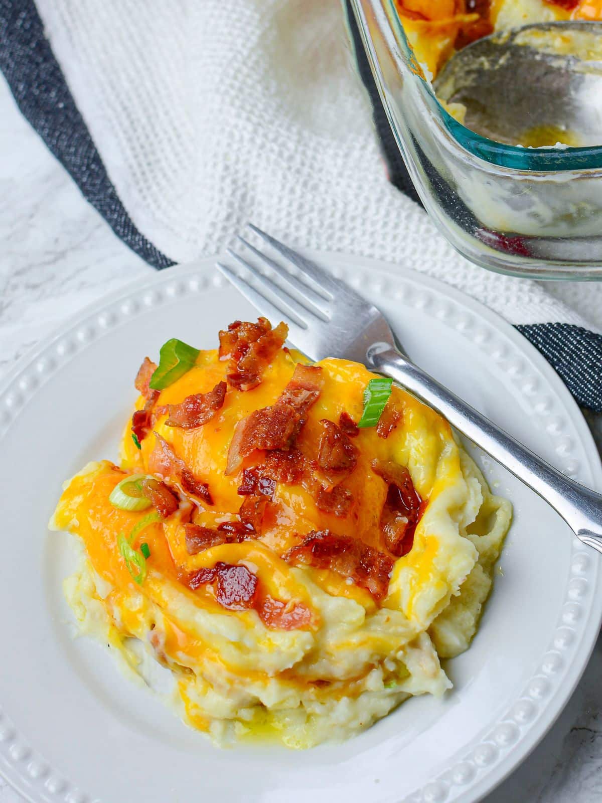 Mashed potato casserole served on white plate and fork.