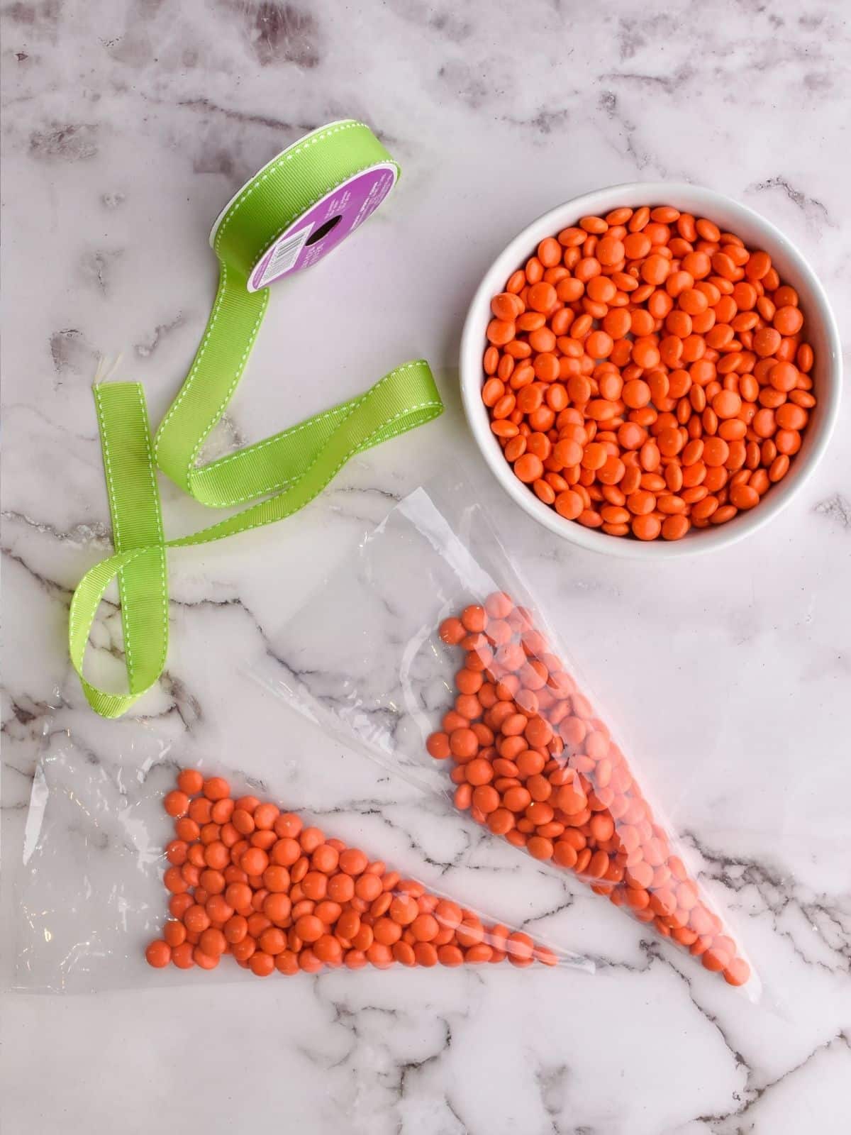 bowl or orange candy and cellophane bags filled with candy pieces.