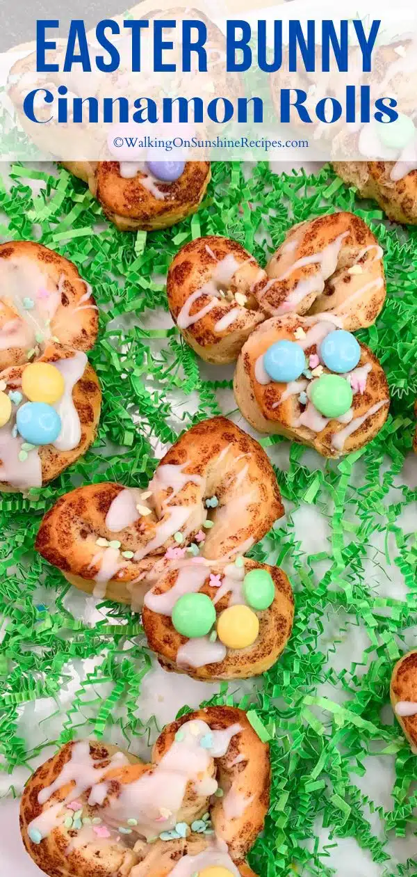 Bunny Cinnamon Rolls decorated with icing and M&M's on white tray with green paper grass.