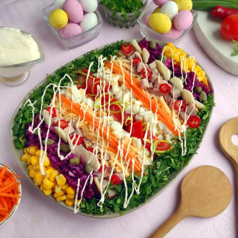 salad with tomatoes, corn, red cabbage, ham, lettuce and salad dressing.