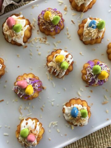 Mini bundt cakes from a cake mix topped with toasted coconut, icing and candies.