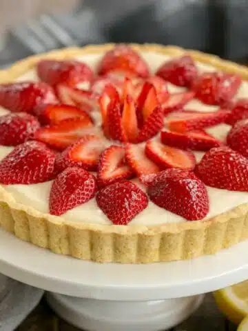 Fresh strawberry tart on white platter.