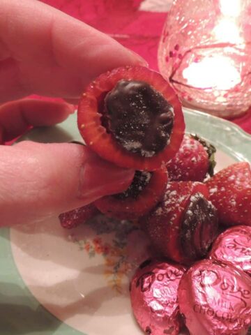 melted chocolate in hulled out strawberries.