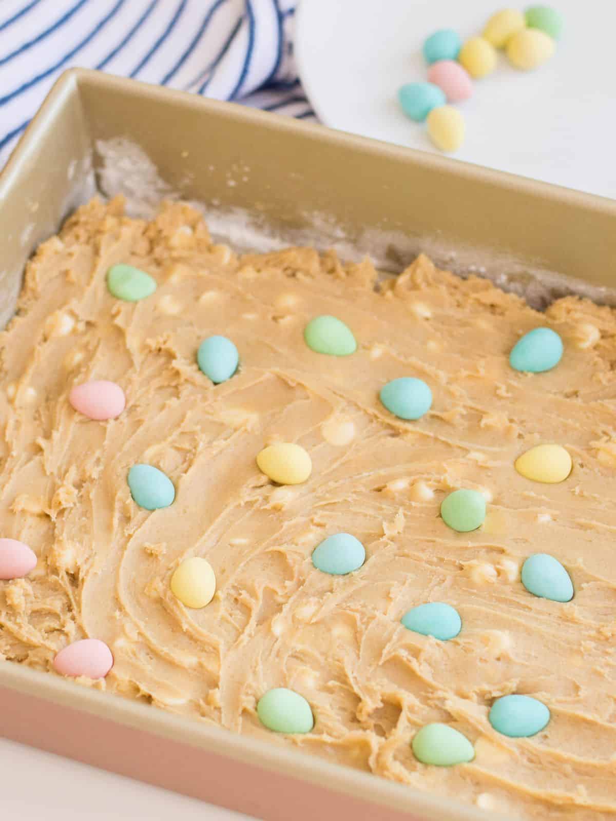 candy Easter eggs pressed into raw cookie dough in pan.