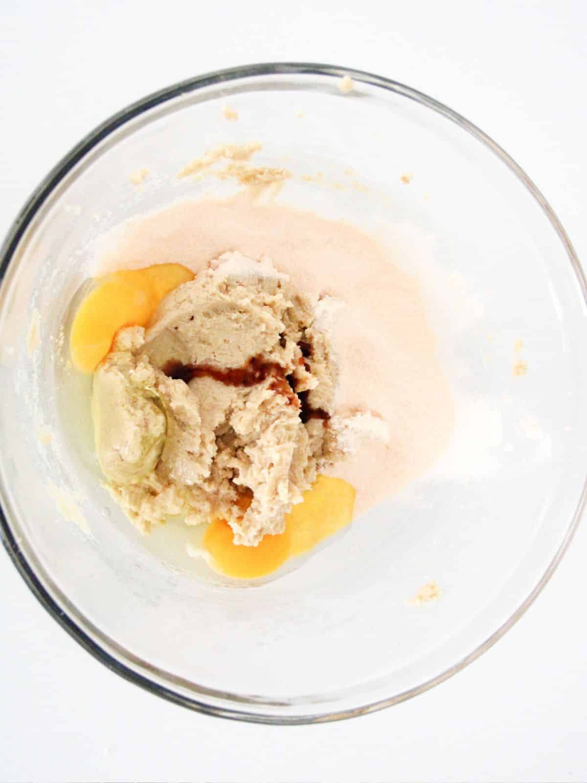 eggs and vanilla added to creamed butter and sugars in clear bowl.