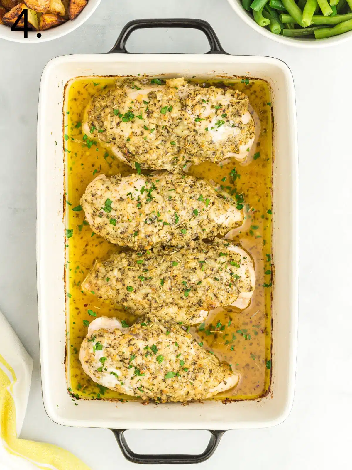 baked chicken in casserole dish with garlic butter and herbs.