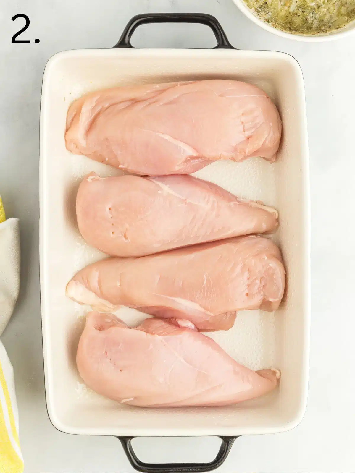 raw chicken breasts in casserole dish.
