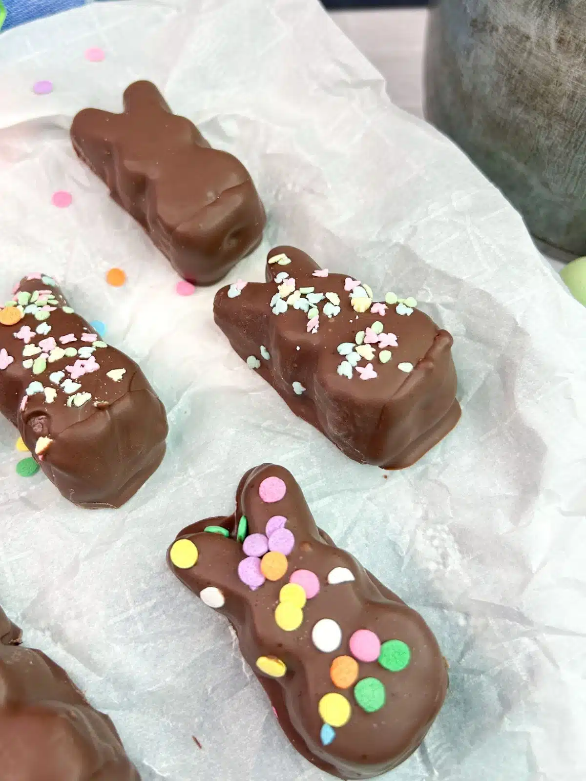 chocolate bunnies with sprinkles on white parchment paper.