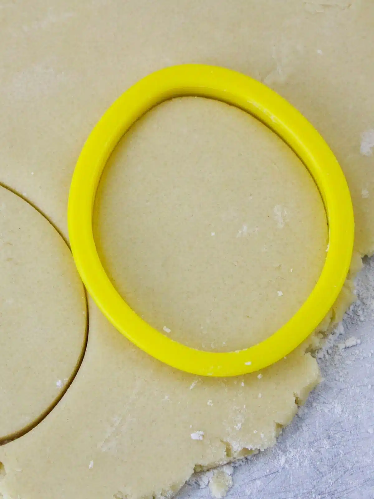 egg shaped cookie cutter on top of rolled out sugar cookie dough.