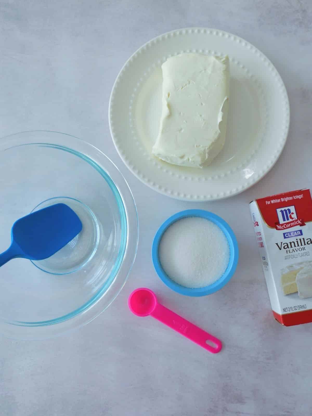 cream cheese in bowl, sugar in bowl and vanilla extract.