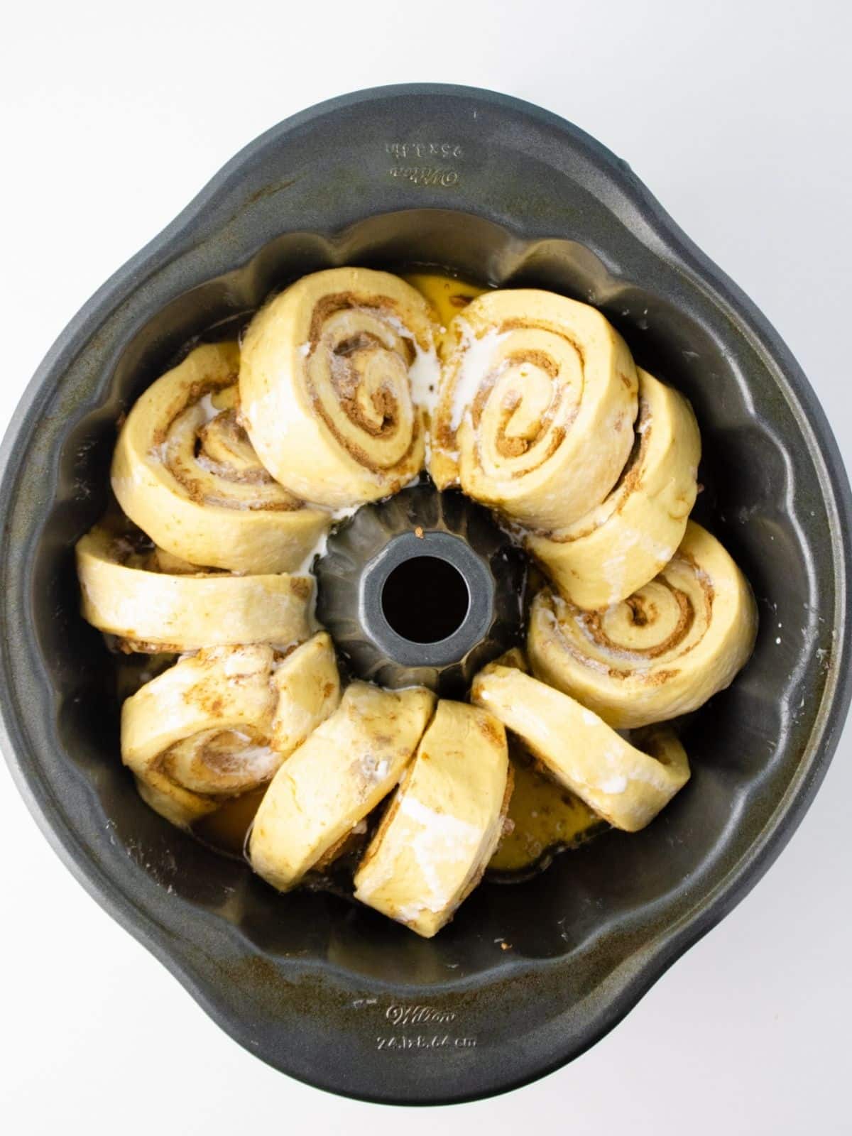 Heavy cream poured over the cinnamon rolls