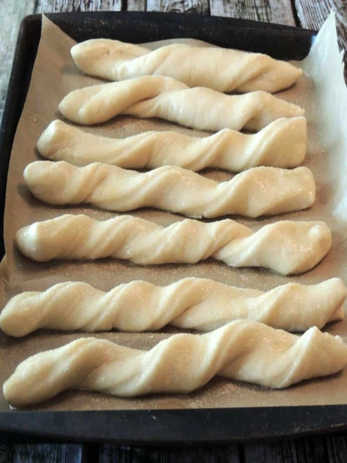 twisted breadsticks on baking tray before baking.