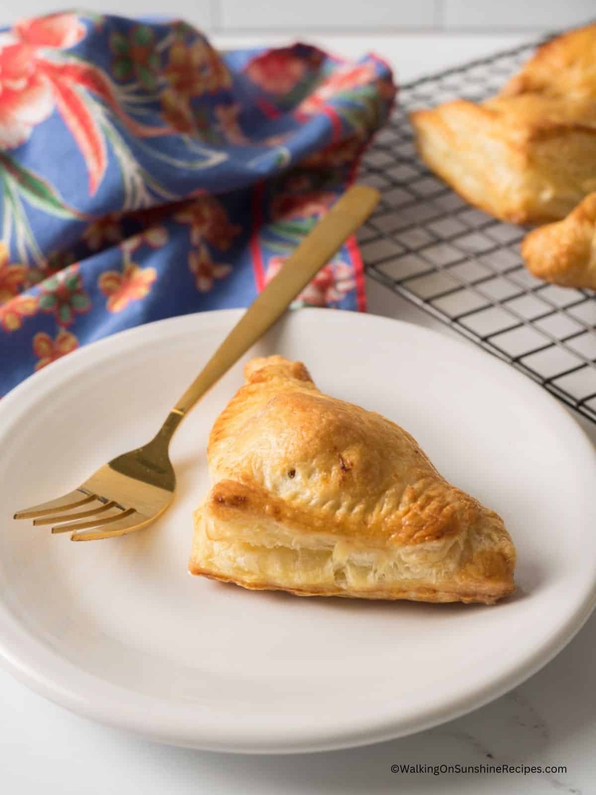 Chicken Puff Pastry Pocket served on a white plate with a gold fork.