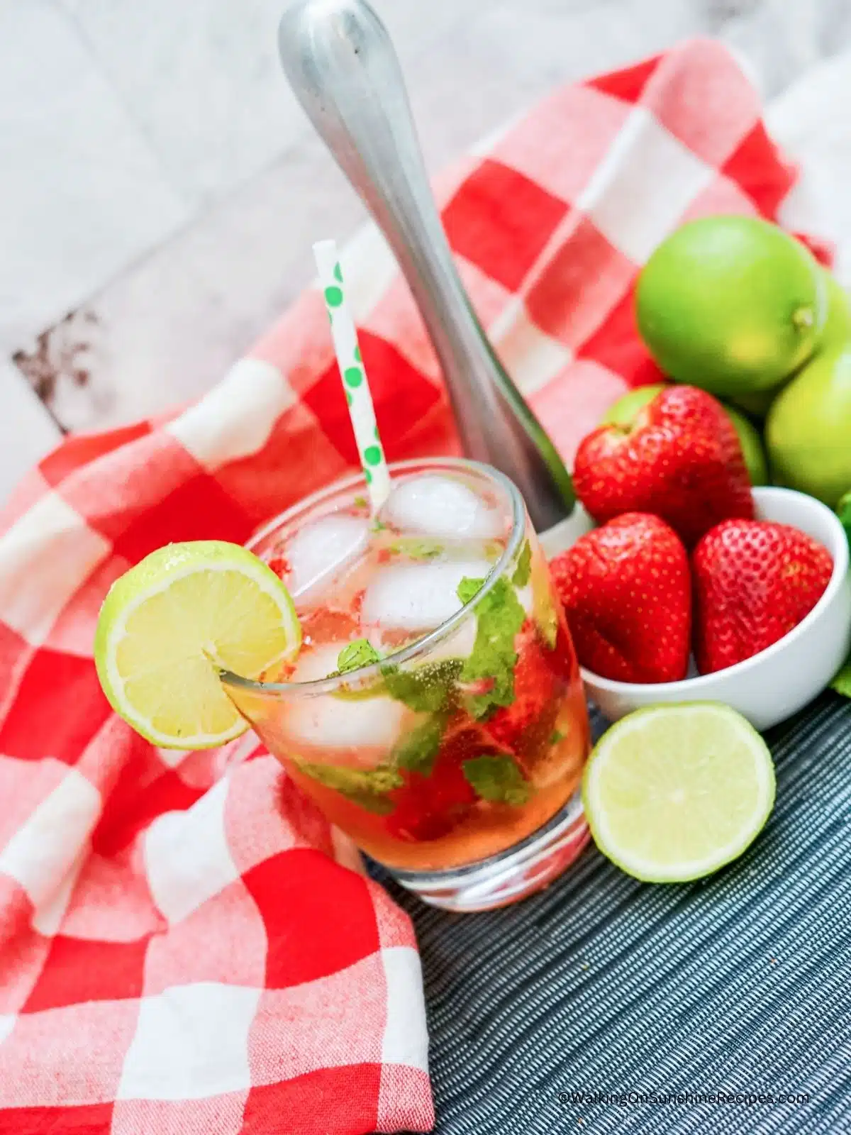 glass of strawberry sparkling water with limes.