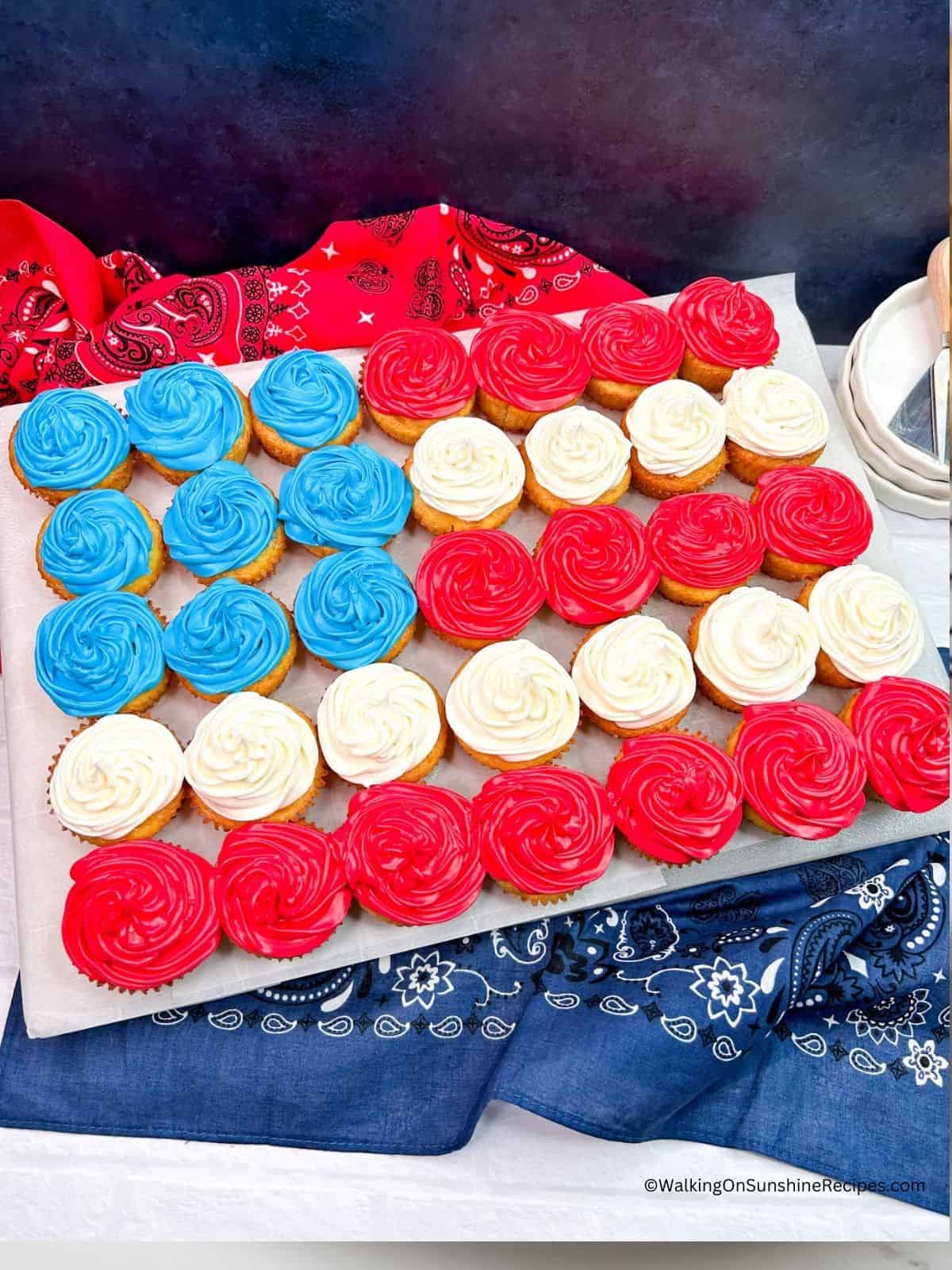 red, white and blue cupcakes on white board.