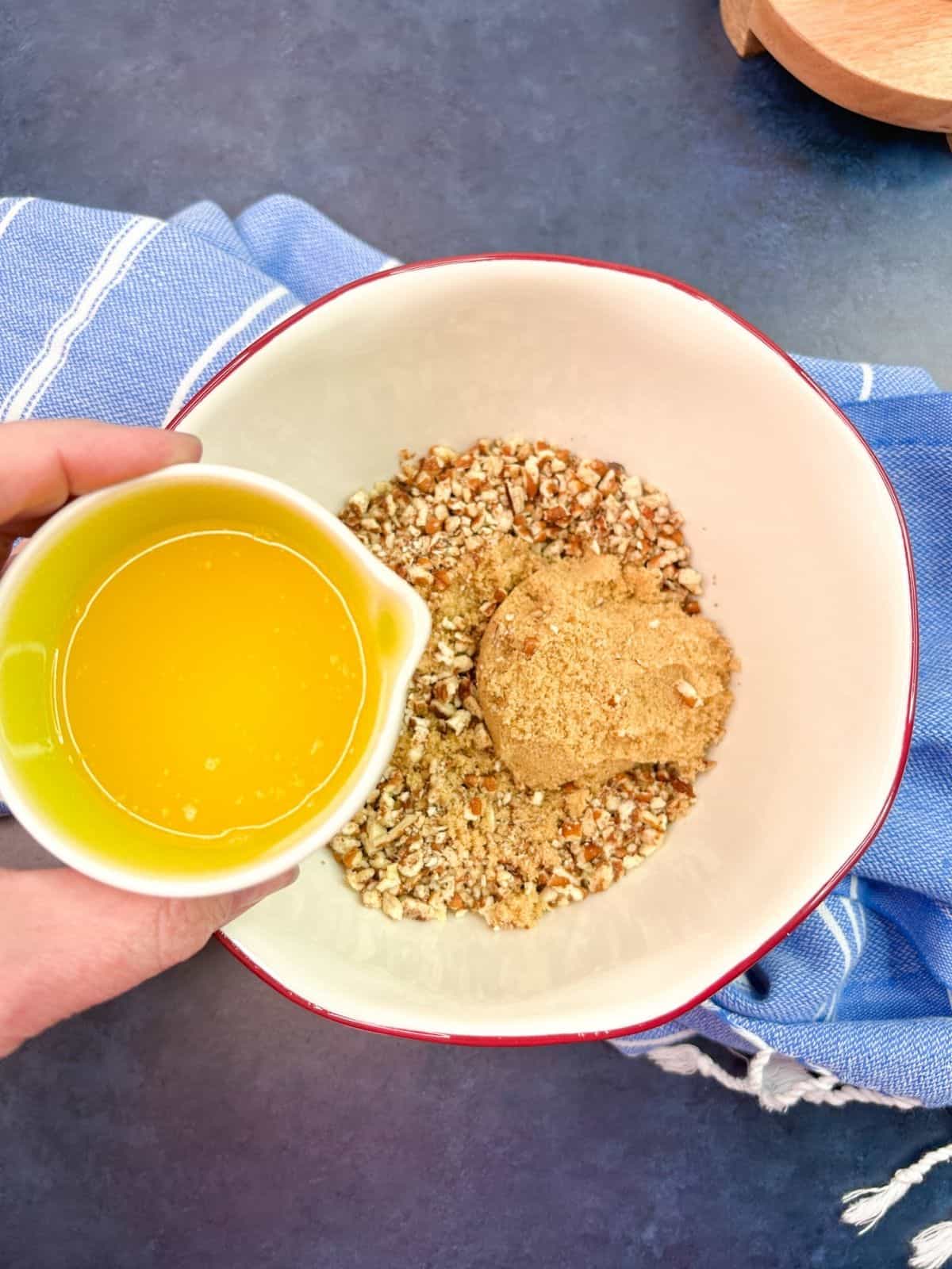 Add melted butter to chopped pecans and brown sugar in bowl.
