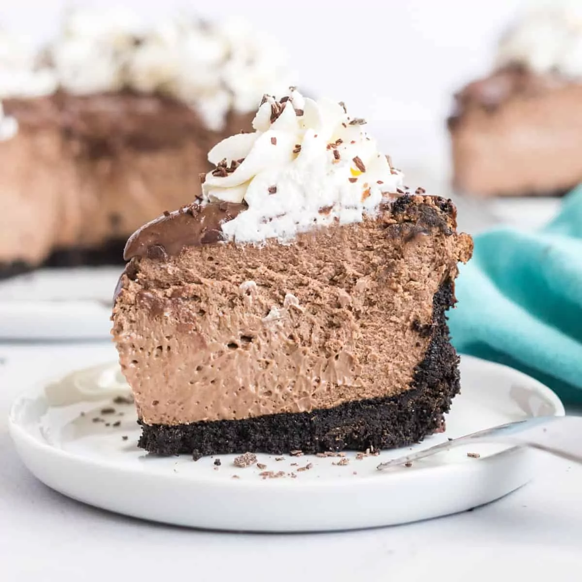 thick slice of chocolate cheesecake with whipped cream topping.