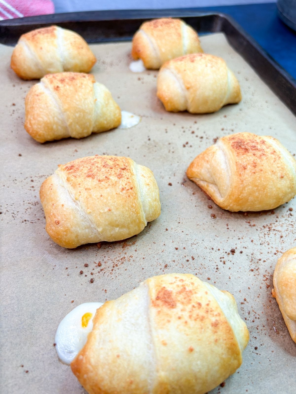 Crescent rolls with cheese and pepperoni baked on baking tray.
