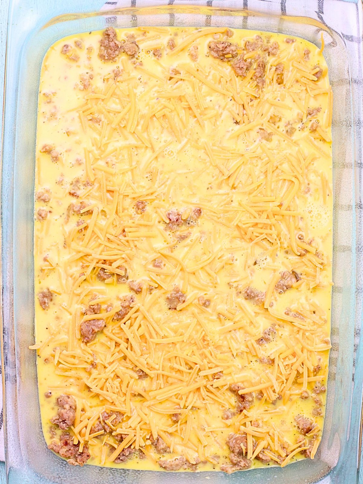 eggs and sausage and cheese in casserole dish.